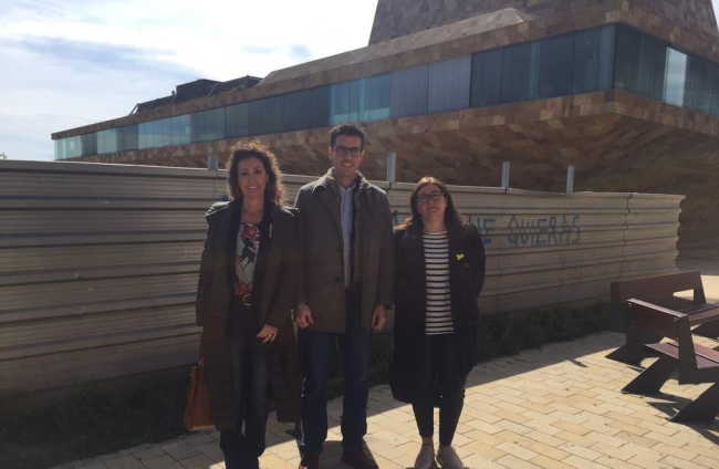 Postius, amb les edils Marta Gispert i Cristina Simó, davant del solar.