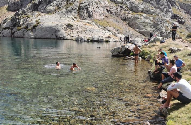 Excursionistas bañándose en uno de los lagos alpinos de la montaña de la Pica d’Estat, en Âreu, práctica que está prohibida.