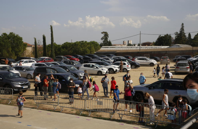 Imagen de grupos de padres esperando ante las puertas de sendos colegios de Lleida esta semana. Ahora, los centros no les permiten entrar en sus patios.