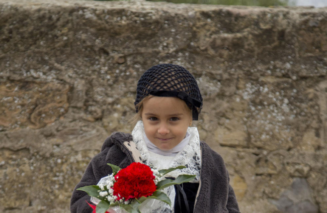 Una de les nenes que van dipositar les flors en representació de la seua escola.