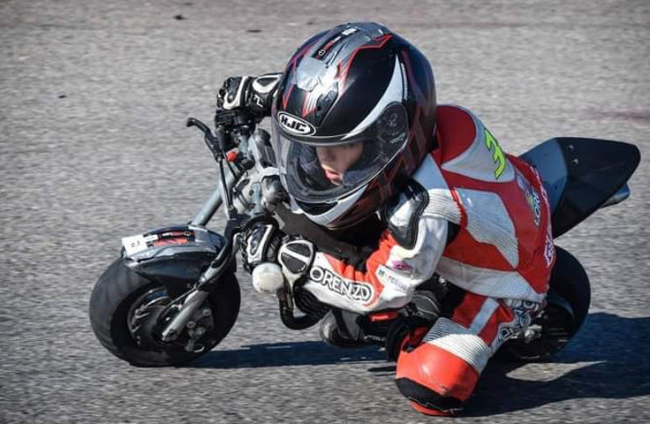 Aleix posa amb la moto que pilota a les FIM MiniGP World Series que van arrancar fa una setmana.