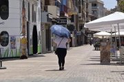 El paraigua s’ha convertit en un accessori imprescindible per protegir-se en les hores de més sol. - AMADO FORROLLA