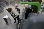 Un empleat d’un restaurant de Lleida llençant envasos de botelles al contenidor de reciclatge.