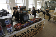 Dos treballadores atenent la nova cafeteria provisional habilitada a l’estació de Lleida Pirineus.