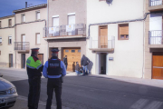 Mossos custodiant la casa on es va produir el succés, en primer pla, i agents d’investigació i de la científica, al fons.