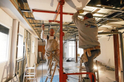 Dos operarios trabajando en la adecuación del local para que funcione como equipamiento residencial de salud mental.