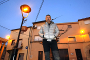 El alcalde de Ivars de Noguera, Josep Magrí, junto a una farola iluminada con leds de color ámbar.