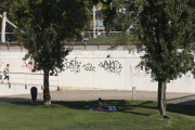 Dos jóvenes se resguardaban ayer del calor a la sombra de los árboles cerca del río Segre. 