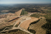 Vista aérea de la presa de L’Albagés, de tierra compactada, que regula el río Set y ya contiene agua.