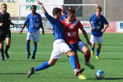 Un jugador del equipo local y uno del visitante se disputan por el balón.