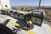 Operarios instalando los contenedores de recogida selectiva junto a los viejos en una de las islas delimitadas por el ayuntamiento de Alfés. 