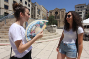 Dos joves poloneses intenten apaivagar la calor a la plaça Sant Joan de Lleida.