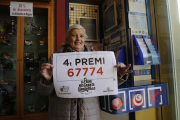 La propietaria del estanco de la Estación Lleida-Pirineus, con el cartel del cuarto premio.