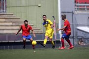 Un jugador del Tàrrega desplaça la pilota davant la pressió de dos jugadors del Martinenc.