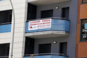 Imagen de un edificio con cartel de alquiler de piso.