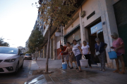 Los vecinos ayer con cubos y una manguera regando los árboles en Cardenal Cisneros.