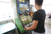 Un usuario jugando en una máquina tragaperras en un bar de Lleida. 