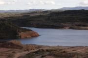 Operarios trabajaban ayer en la reposición de caminos en el entorno del pantano, al fondo.