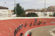 Ciclistas entrenando persecución tras moto en el velódromo.