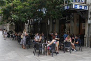 Imagen de una terraza de un bar con clientes junto a la plaza Sant Joan de Lleida ciudad.