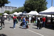 Clientes haciendo cola ante un puesto de venta del mercado del Barris Nord y, a la derecha, una línea de cajas de madera para delimitar la separación de seguridad.