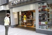 La librería Caselles de Lleida ayer, atendiendo a los clientes con cita previa en la puerta del comercio.