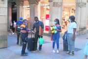 Varias personas conversan anoche frente a la entrada del pabellón 3 de la Fira donde pernoctan. 