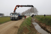 Un camió grua va extreure el cotxe de l’interior de la segona séquia del Canal d’Urgell.