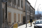 Un hombre junto a las antiguas casas de los ferroviarios, valladas por riesgo de desprendimientos.