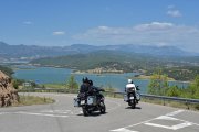 Motoristas pasando por el pantano de Rialb. 