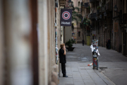 Una mujer habla por teléfono en una calle del centro de Barcelona, desierta por la orden de confinamiento.