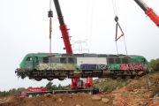 Imagen de las dos grúas levantando la locomotora de Captrain siniestrada entre Vinaixa y Vimbodí por el temporal de octubre, con la línea de alta tensión al fondo. 