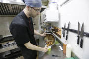 Un cocinero del restaurante ‘Des-Tapa’t’ de Lleida guardando la comida en un táper. 