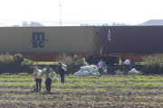 Campo a través la gente cargaba con el material de los contenedores del tren descarrilado entre Puigverd de Lleida y Juneda. 