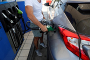 Un home es proveeix en una gasolinera.