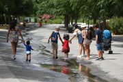 Varios niños pasan por un arroyo de agua en el Parc Central, a 12 de agosto de 2021, en Valencia, Comunidad Valenciana (España).