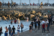 Persones migrants caminen per la platja del Tarajal, a Ceuta