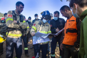 Els equips de rescat consultant un mapa ahir abans que es trobés el nen.