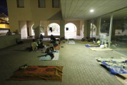 Un grup de temporers dorm al ras al carrer Nou.