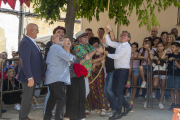 El conseller Giró, a la derecha con camisa, participando en el concurso para subir sacos con polea.