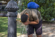 Un jove refrescant-se ahir en una font a Lleida.