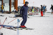 El rey Felipe VI esquiando ayer en Baqueira (izquierda) y un gran número de esquiadores en la estación de Port Ainé, que cerró su acceso al completar su aforo. 