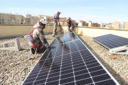 Operarios instalando placas solares en el instituto Maria Rúbies.