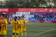 Jugadors del Lleida, diumenge a Vic amb la pancarta al fons que va mostrar l’afició lleidatana.