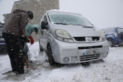 Dos persones posant cadenes al seu vehicle ahir a la tarda al port de la Bonaigua.