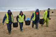 Operaris de neteja retiren els pèl·lets de plàstic en una platja d’O Vilar, a la Corunya.