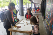 Jocs infantils ahir amb Artistalia als porxos de l’Espai MerCAT per protegir-se de la pluja.