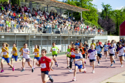 Una cursa femenina passant per davant de la grada plena de públic.