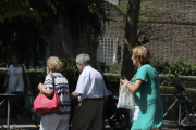 Un grup de persones grans passegen per un parc aprofitant el bon temps.