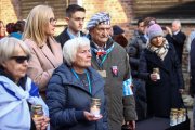 Supervivientes del campo de concentración y de exterminio nazi de Auschwitz y sus familiares depositan velas frente al emblemático 